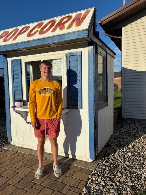 Tucker Pecha is standing by the popcorn stand.