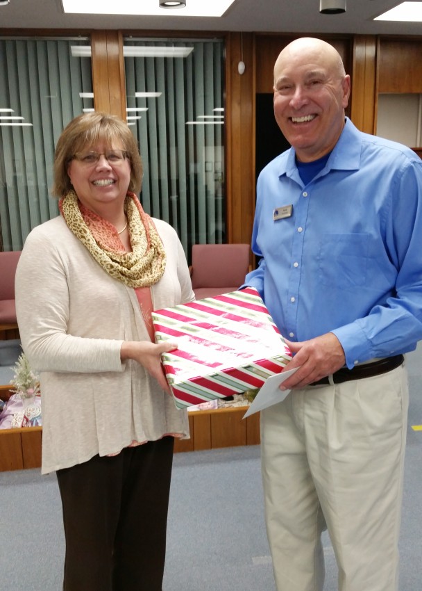 Donnis Borcherding presenting a wrapped gift to Randy in honor of his anniversary.